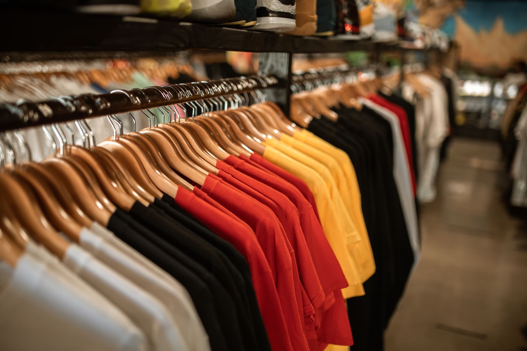 Farbige Shirts auf Kleiderbügeln in einem Bekleidungsgeschäft